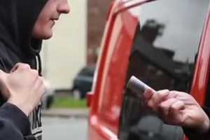 Young person taking money off a man in a van