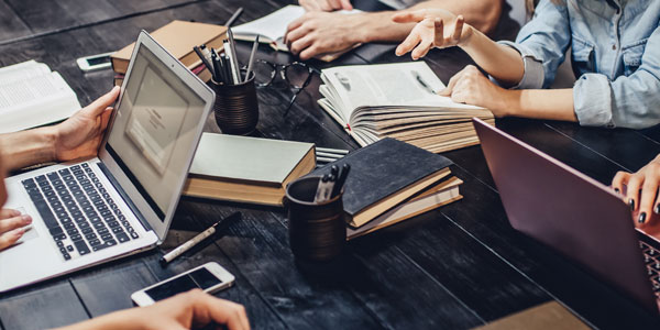 Laptop, books and pens on a table